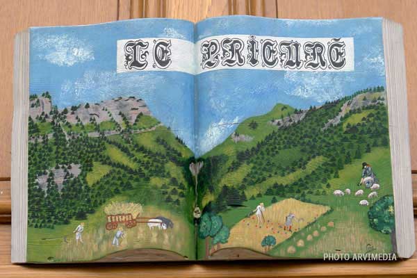 sculpture murale représentant un livre avec des laboureurs et des paysans au travail